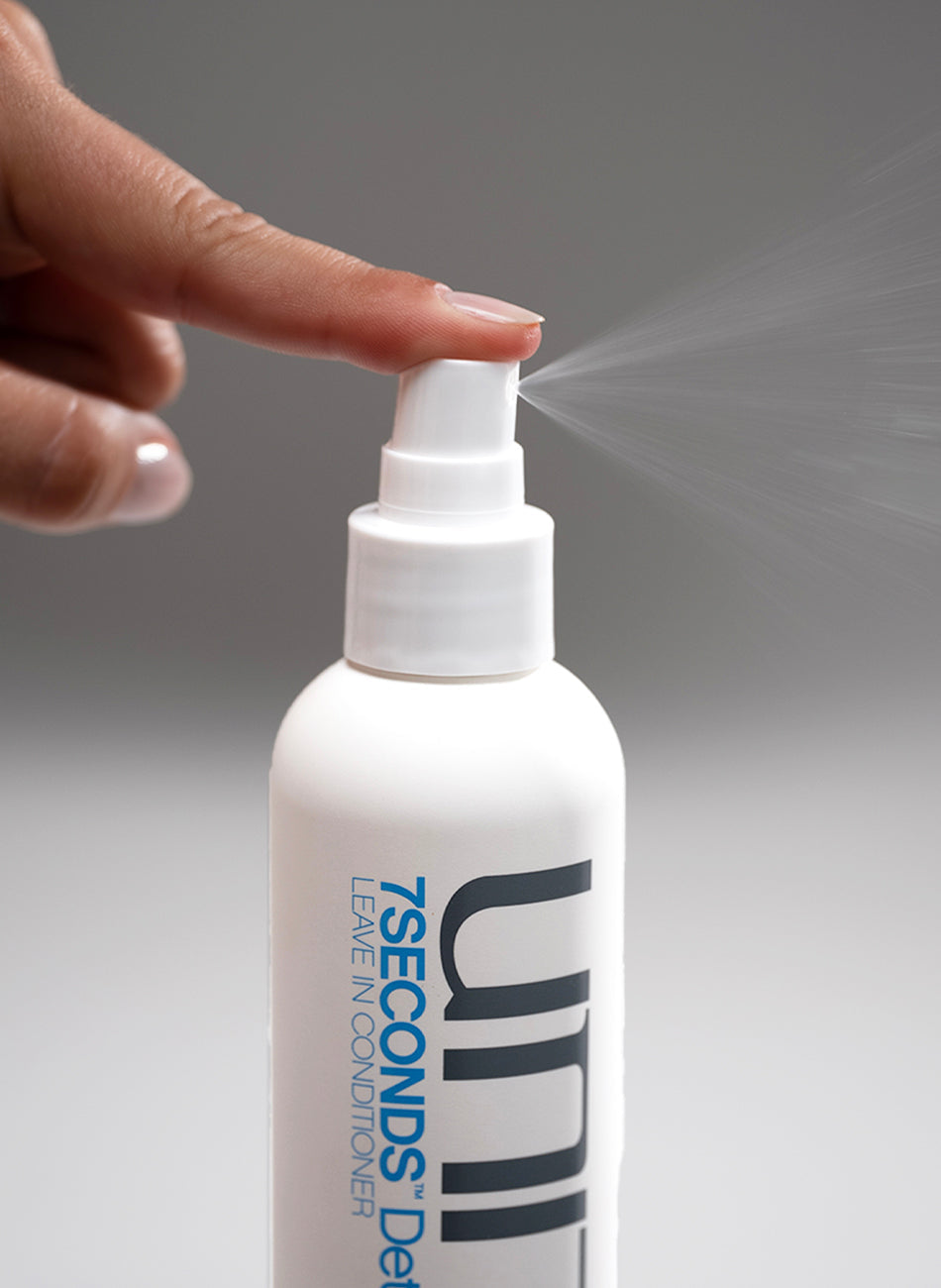 Hair detangler leave-in conditioner being sprayed from a bottle for smooth and manageable hair.