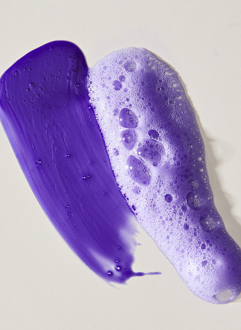 Texture and lather of purple shampoo on a light background.